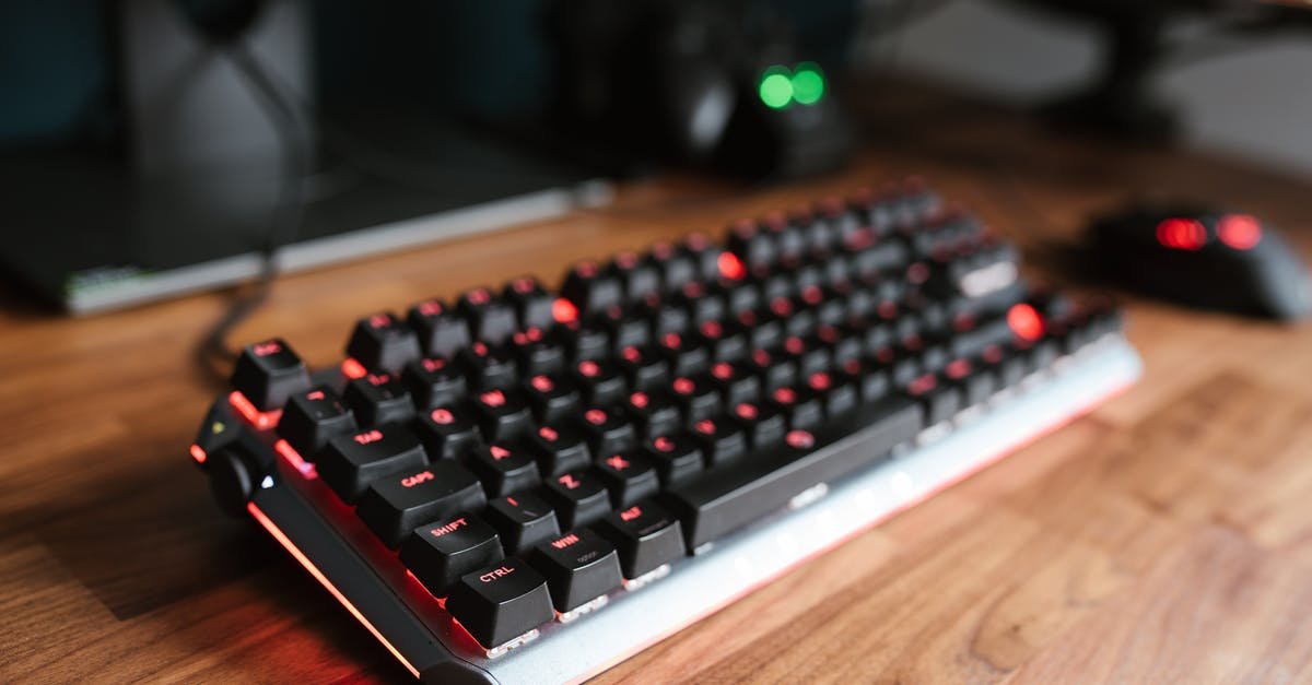 A close up of a computer keyboard sitting on top of a wooden table