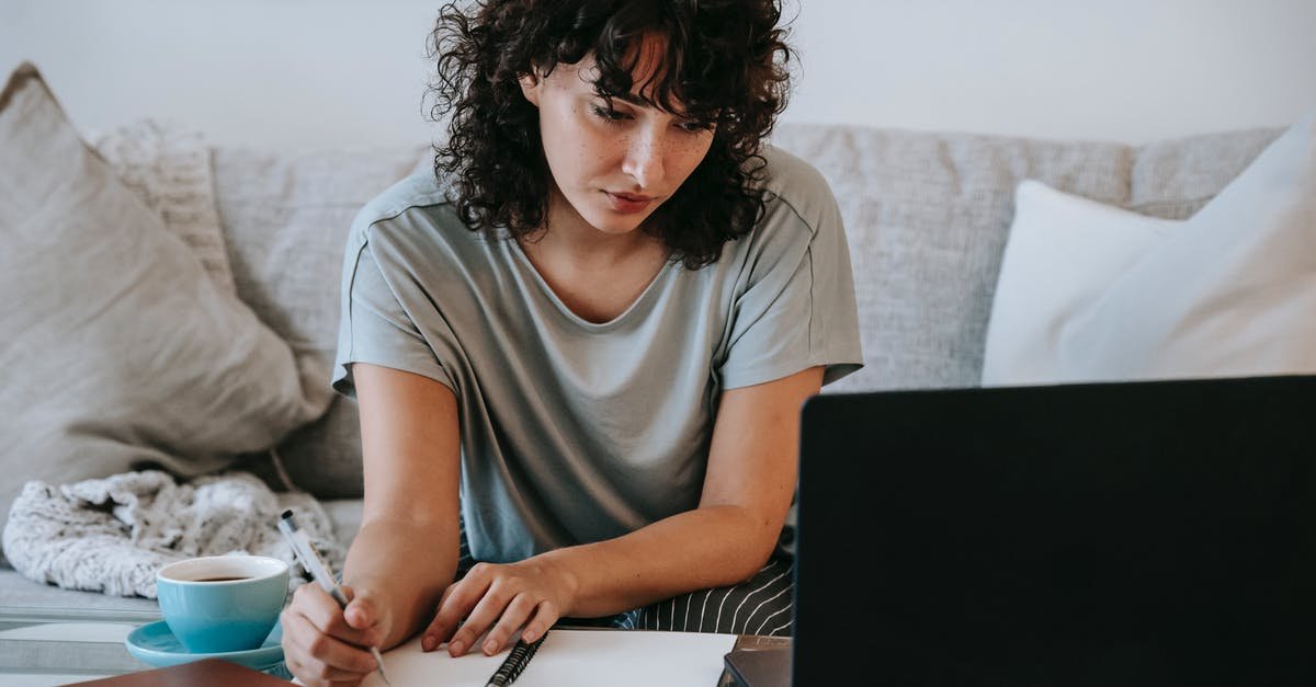 A person sitting at a table using a laptop computer