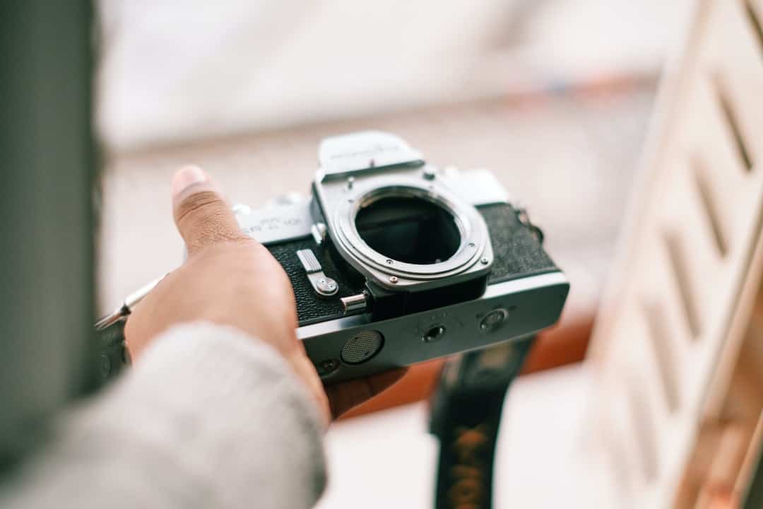 A hand holding a camera