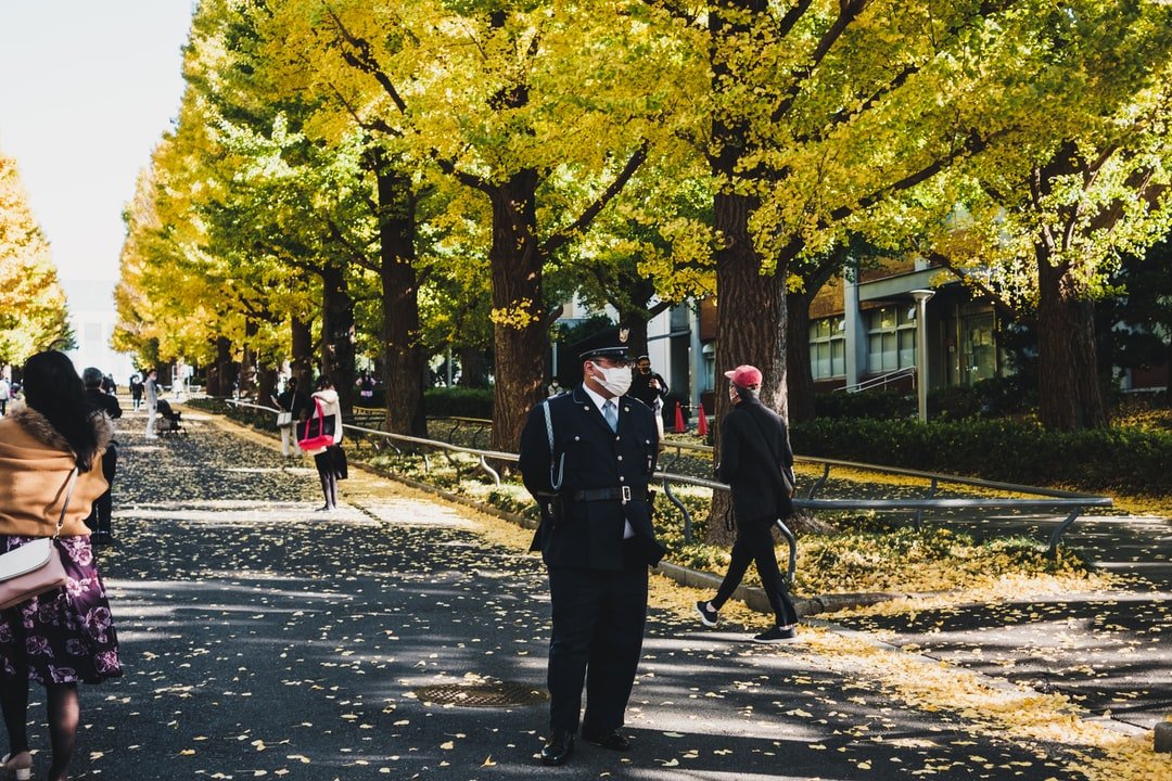 A group of people walking on a sidewalk