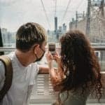 A man and a woman looking at her cell phone