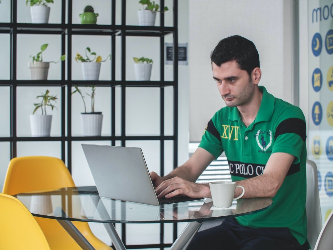 A man sitting at a table using a laptop